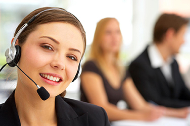 A woman with a headset on smiling for the camera.