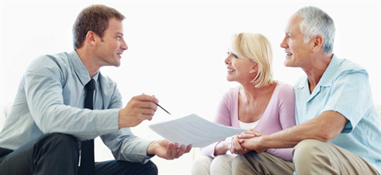 A man and woman are sitting in front of papers.